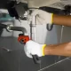 plumber fixing white sink pipe with adjustable wrench